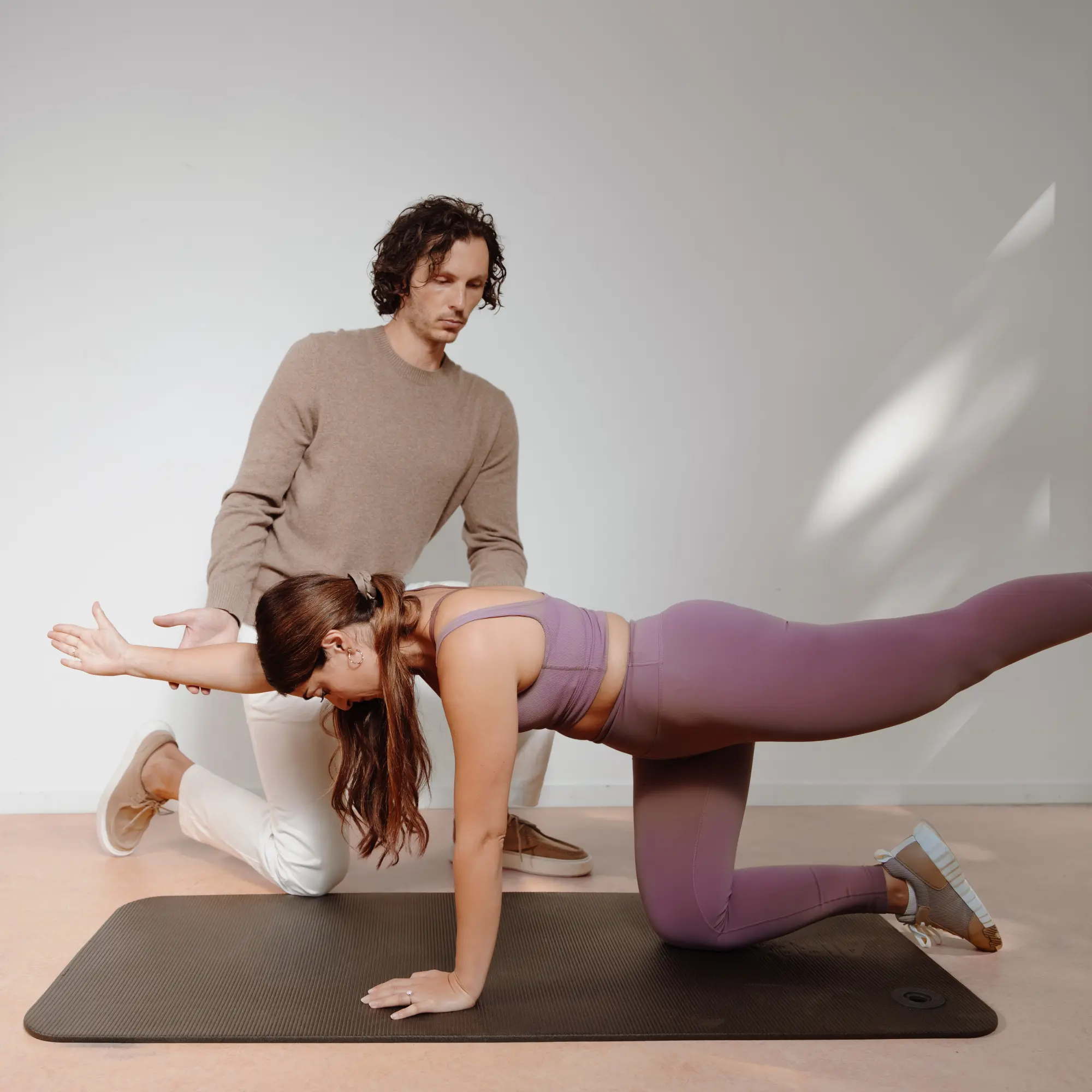Osteopaat begeleidt een sporter tijdens een stabiliteitsoefening